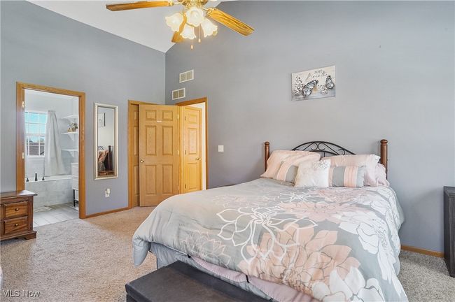 Carpeted bedroom featuring visible vents, ceiling fan, high vaulted ceiling, and baseboards | Image 27