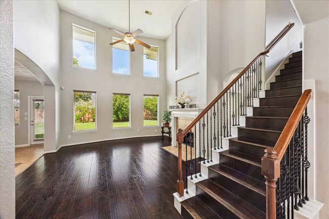 The 2 story glassed window wall in this living room provide lots of daylight and bring the outdoors inside with beautiful views of the backyard. | Image 15