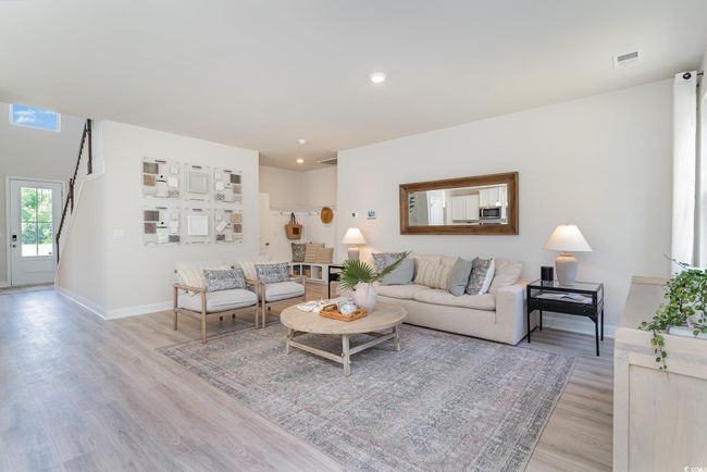 Living area with light wood finished floors, visible vents, baseboards, stairway, and recessed lighting | Image 9