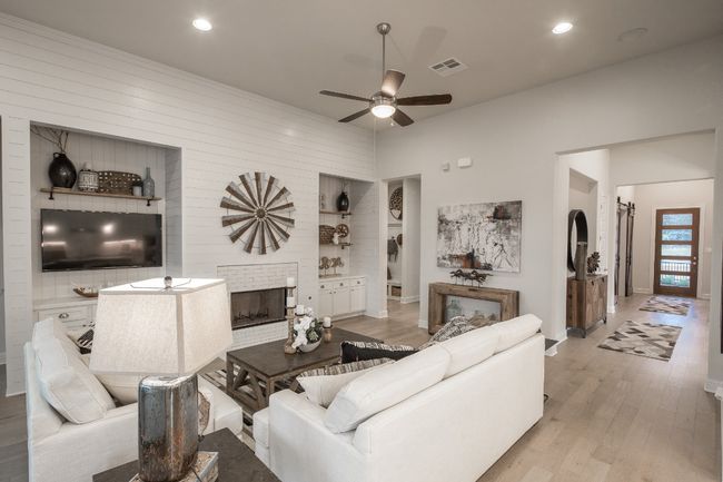 Living area featuring a ceiling fan, light wood-style flooring, a fireplace, baseboards, and recessed lighting | Image 14