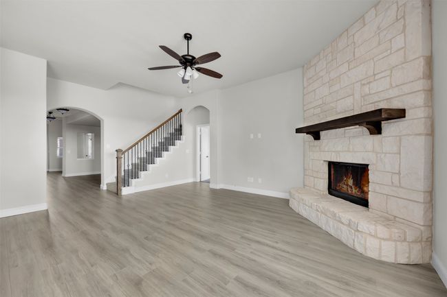 Living room with a fireplace, light hardwood / wood-style floors, and ceiling fan | Image 15