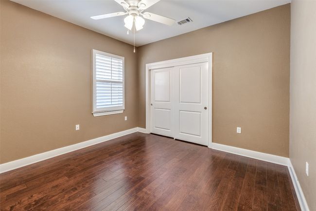 Unfurnished bedroom with a closet, dark wood-style floors, baseboards, and visible vents | Image 17