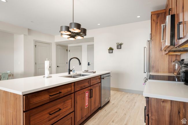 Kitchen with a sink, dishwasher, light countertops, a kitchen island with sink, and recessed lighting | Image 45