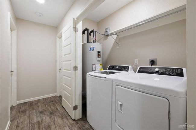 Laundry room with washer and clothes dryer and wood finished floors | Image 11