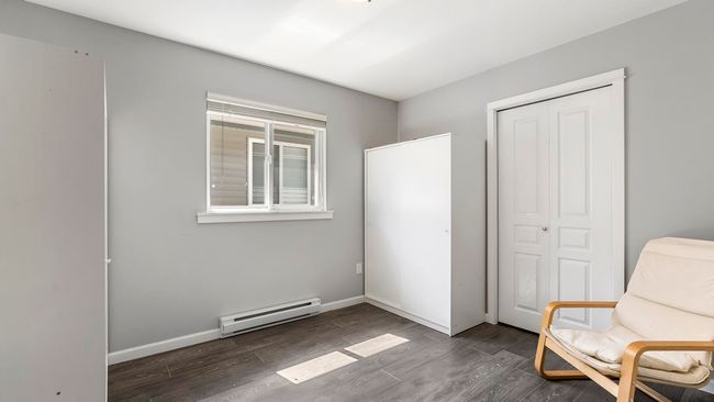 Sitting room with dark wood-type flooring, baseboards, and baseboard heating | Image 20