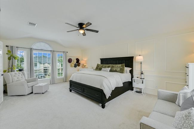 Carpeted bedroom featuring a decorative wall, lofted ceiling, and a ceiling fan | Image 18
