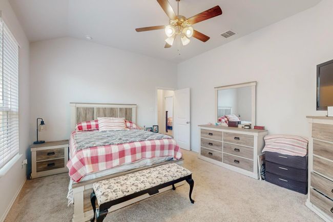 Bedroom with visible vents, baseboards, a ceiling fan, light colored carpet, and lofted ceiling | Image 13