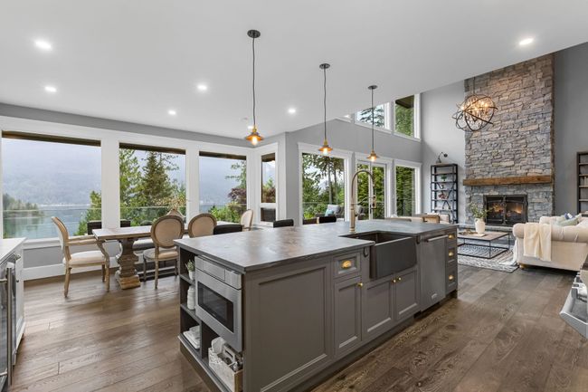 Kitchen with gray cabinets, a sink, a fireplace, appliances with stainless steel finishes, and dark wood-type flooring | Image 6