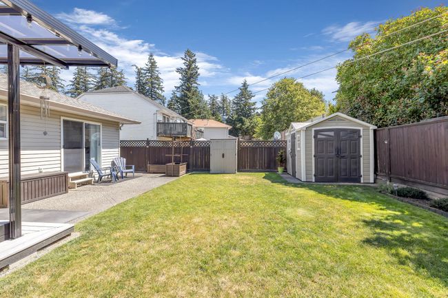 View of yard with a shed, a patio area, a fenced backyard, and an outbuilding | Image 28