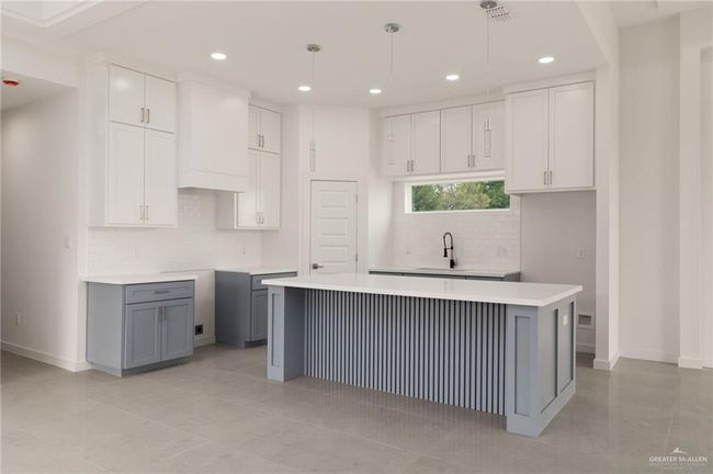 Kitchen featuring a kitchen island, decorative backsplash, recessed lighting, gray cabinets, and hanging light fixtures | Image 6