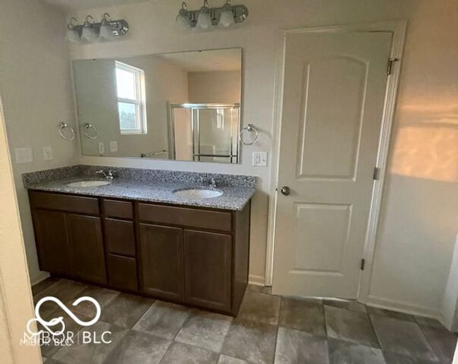 bathroom featuring a shower stall, double vanity, and a sink | Image 16