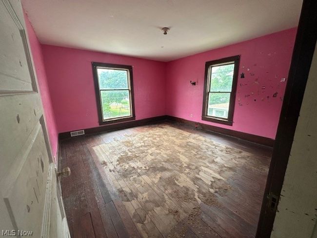 Spare room with a healthy amount of sunlight and dark wood-type flooring | Image 13