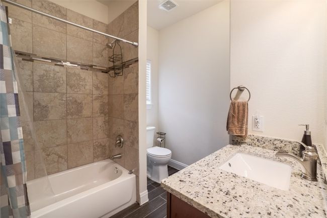 Full bathroom with shower, tub and the gorgeous granite countertop adorned with a waterfall fixture. | Image 23