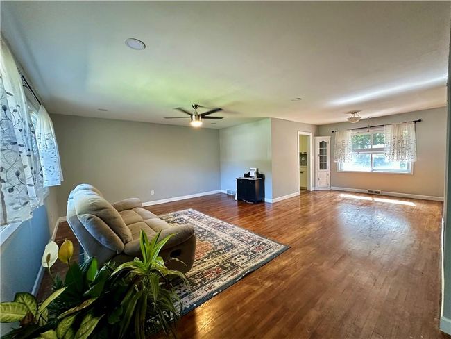 Living room featuring ceiling fan and wood-type flooring | Image 12
