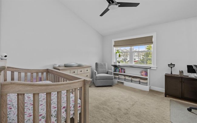 Bedroom featuring lofted ceiling, carpet, a ceiling fan, a nursery area, and baseboards | Image 17