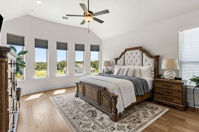 Bedroom with lofted ceiling, visible vents, and multiple windows | Image 23