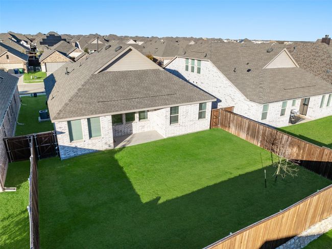 Back of house with a residential view, a patio area, a shingled roof, and brick siding | Image 25