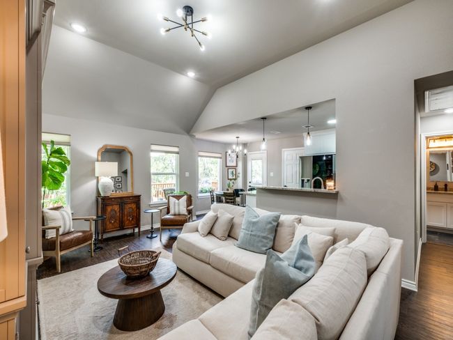 Living area featuring a chandelier, dark wood-style floors, vaulted ceiling, recessed lighting, and baseboards | Image 5
