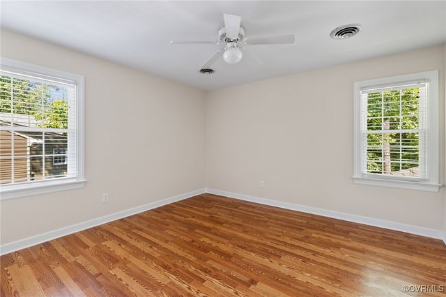 Bedroom 4 with healthy amount of natural light, laminated wood flooring and a ceiling fan with light | Image 33