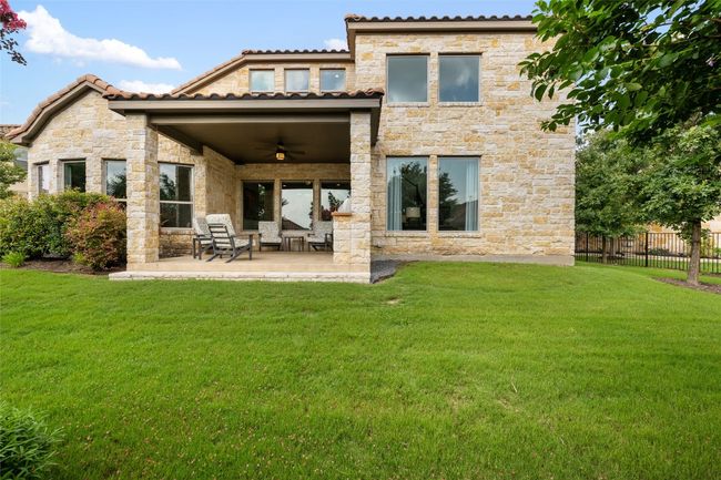Back of house featuring ceiling fan, a patio area, and stone siding | Image 35