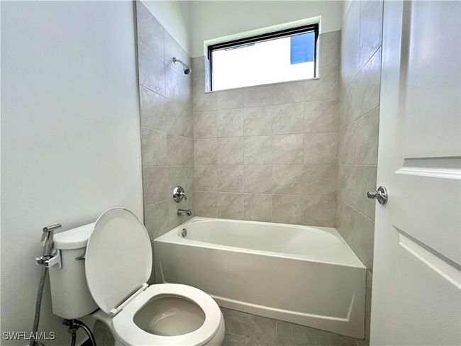 Bathroom with tiled shower / bath and toilet | Image 25