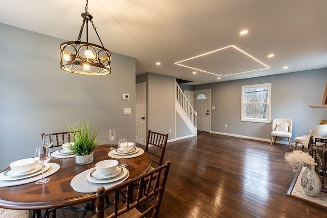 Dining space featuring baseboards, recessed lighting, wood finished floors, and stairs | Image 9