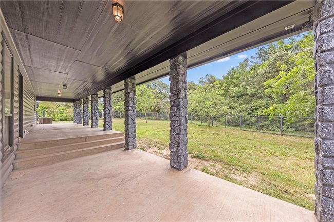 Fenced backyard with a patio | Image 32