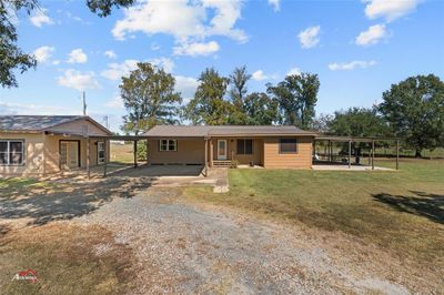 Single story home featuring a patio, a front yard, and a carport | Image 1