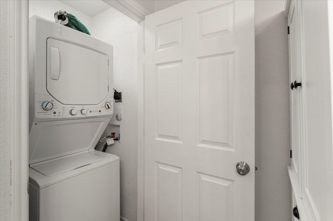 Clothes washing area with stacked washing maching and dryer and laundry area | Image 30