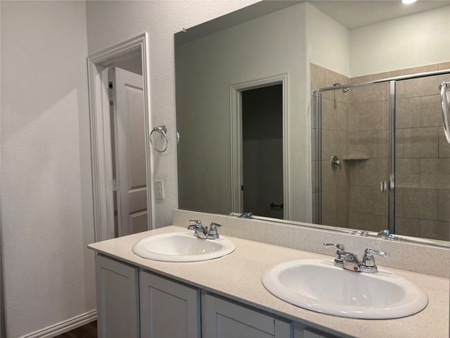 Full bathroom featuring a stall shower and double vanity | Image 11