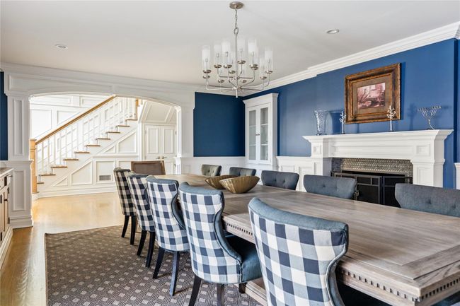 Dining area with arched walkways, a chandelier, wood finished floors, stairway, and a decorative wall | Image 22