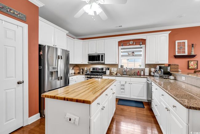 Kitchen with white cabinetry, kitchen peninsula, and appliances with stainless steel finishes | Image 11