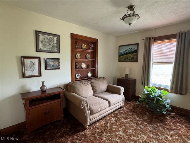 Sitting room featuring dark carpet, baseboards, and a textured ceiling | Image 22