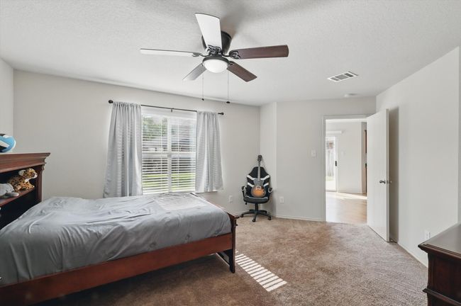 Bedroom featuring carpet floors, a ceiling fan, and a textured ceiling | Image 16