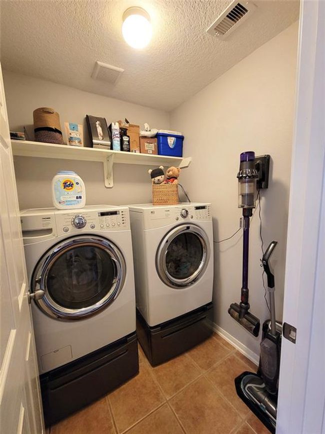 This photo shows a compact laundry room featuring a front-loading washer and dryer set. Washer and Dryer stay! | Image 28