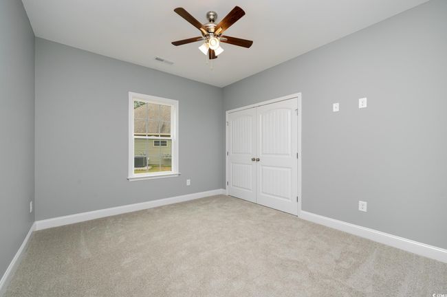 Unfurnished bedroom featuring ceiling fan, light colored carpet, and a closet | Image 11