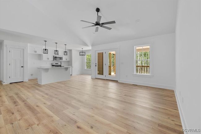 Unfurnished living room featuring a ceiling fan, a wealth of natural light, baseboards, and light wood finished floors | Image 9