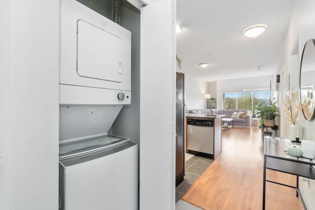 Washroom featuring laundry area, light wood finished floors, and stacked washer and clothes dryer | Image 26