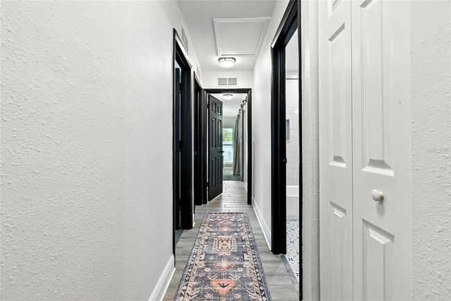 All bedrooms and the guest bath are off this central hallway, complete with wood-like tile. | Image 29