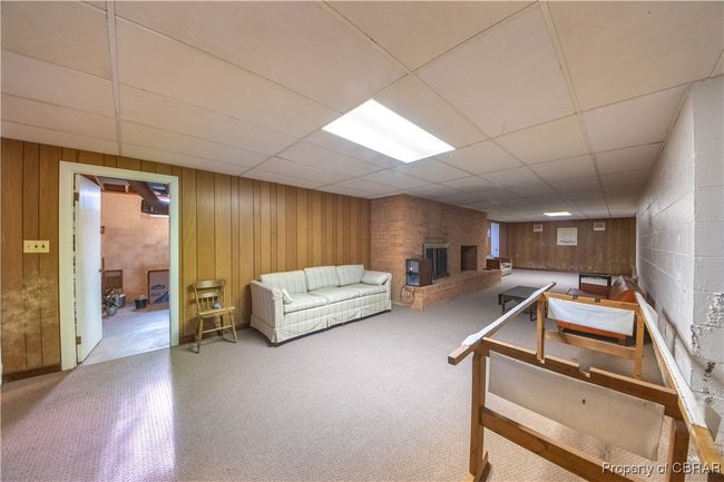 Living room with a fireplace, wooden walls, and a paneled ceiling | Image 29