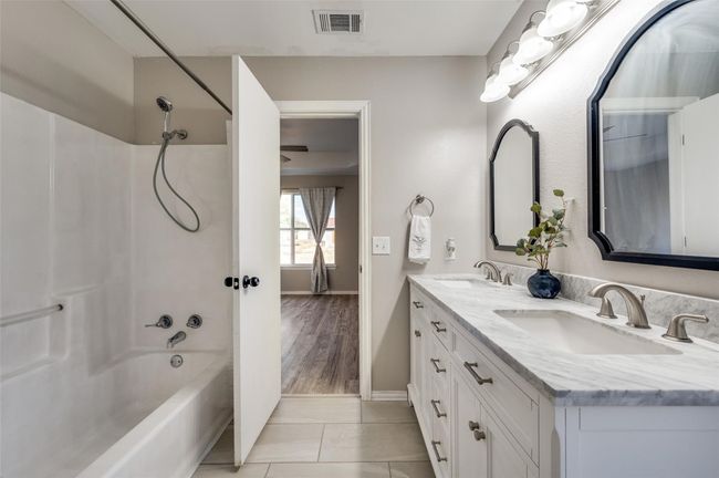 Primary bathroom with double vanity, visible vents, shower combination, and a sink | Image 16