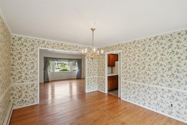 Unfurnished dining area with wallpapered walls, light wood-style flooring, a chandelier, and ornamental molding | Image 19