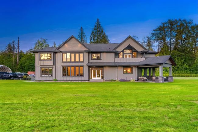 Back of house at dusk with a yard, french doors, and board and batten siding | Image 4
