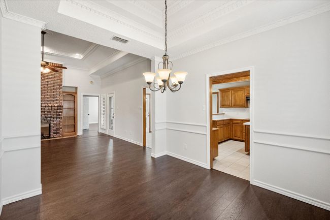 If entertaining is important, this open floorplan has a natural flow. The creamy paint is highlighted by white trim. Custom accents such as chair railing, tray ceiling, crown molding and windows with plantation shutters set the house apart from others in the area. | Image 18