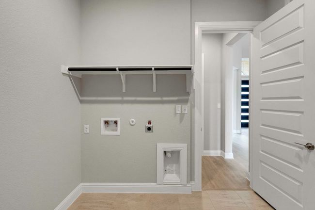 Laundry area featuring gas dryer hookup, electric dryer hookup, washer hookup, and light tile patterned floors | Image 23