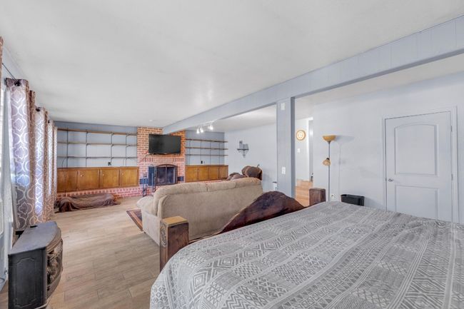 Bedroom featuring wood finished floors and a fireplace | Image 18