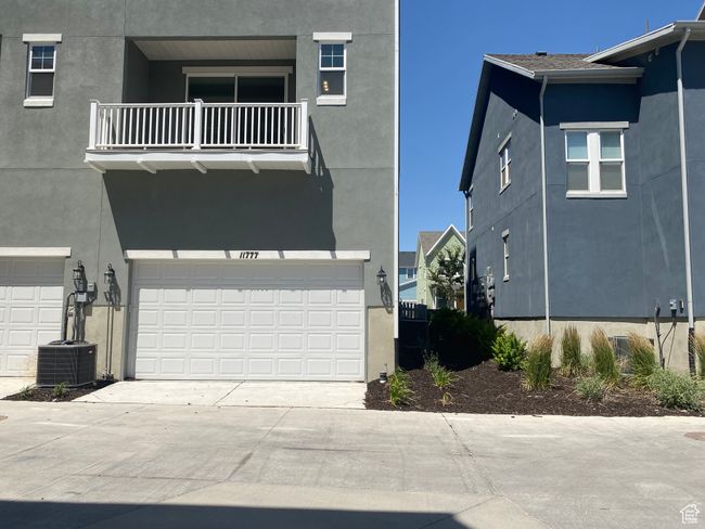 View of front of home with a balcony, stucco siding, an attached garage, and driveway | Image 24
