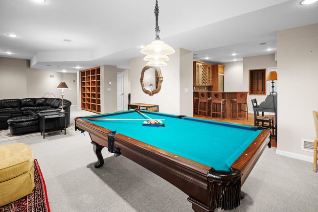 A seamless blend of recreation and relaxation, this lower-level retreat features a game area, wine storage, and built-in entertainment. | Image 38