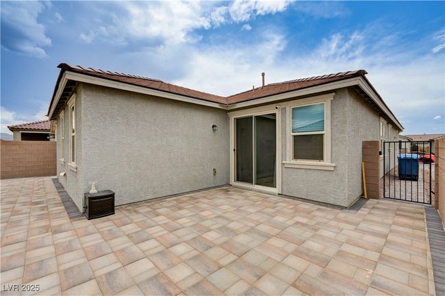 Rear view of property with a gate, stucco siding, a patio area, and a tiled roof | Image 35