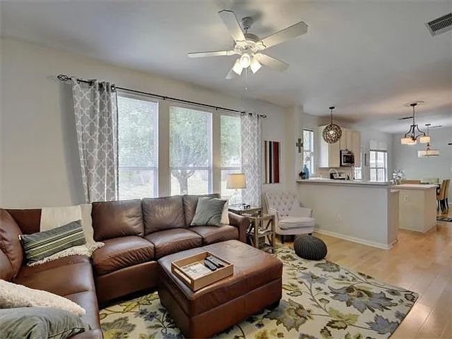 Living area featuring a ceiling fan and light wood finished floors | Image 9